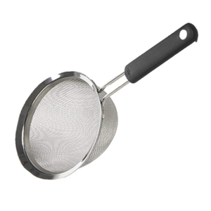 Metal frying pan with a long black handle extending to the right, viewed from an angle.
