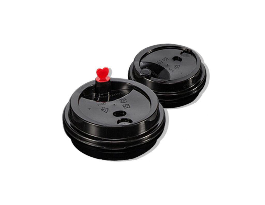 Two black disposable coffee cup lids, one with a small red heart-shaped stopper on top