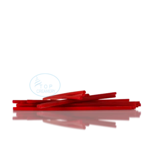 Red plastic straws scattered on a glossy black surface with a blue Top Creamery logo.